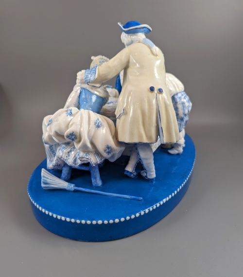 fig 2. Late 19th-century French blue and white glazed porcelain figurine group depicting four figures gathered around a table fortune-telling on an oval blue base.