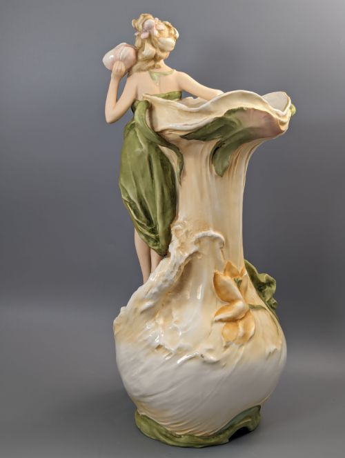 fig 3. An Art Nouveau Royal Dux porcelain vase depicting a draped water nymph holding a seashell against flowing foliage in cream, olive green, and soft pink shades.