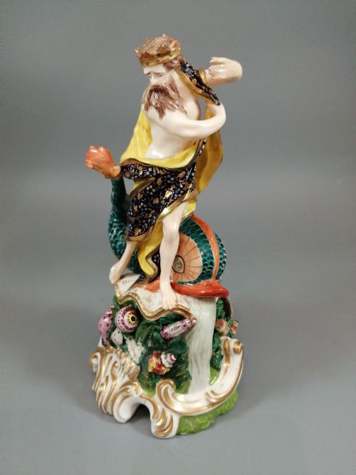 fig 1. A Bloor Derby porcelain figure of Neptune standing atop a shell and rockwork base with sea creatures, wearing a crown and drapery decorated in gold leaf and blue enamel.