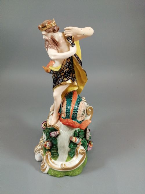 fig 2. A Bloor Derby porcelain figure of Neptune standing atop a shell and rockwork base with sea creatures, wearing a crown and drapery decorated in gold leaf and blue enamel.