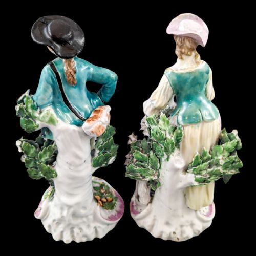 fig 1. A pair of eighteenth-century Derby soft-paste porcelain figurines depicting a shepherd and shepherdess adorned in floral-patterned garments with garlands on scroll bases.