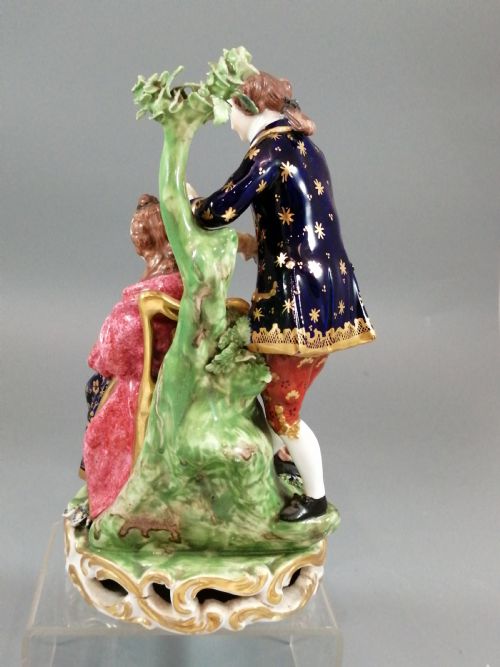 fig 3. An early nineteenth-century painted porcelain figurine depicting a male court hairdresser styling a seated ladys hair on a rococo scroll base.