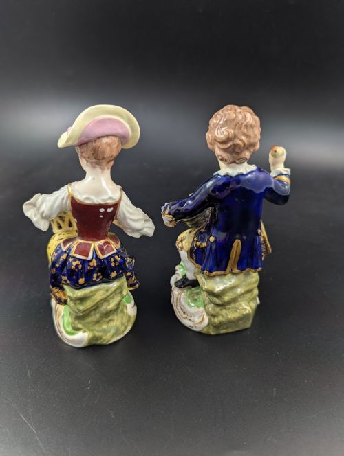 fig 2. A pair of antique hand-painted Derby porcelain figurines featuring a young female gardener with a basket of flowers and a male gardener holding fruit on gilt scroll bases.