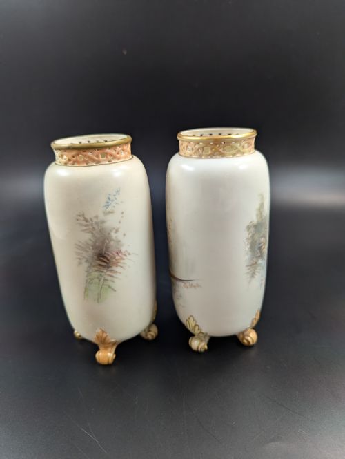 fig 2. A pair of Edwardian Royal Worcester porcelain vases featuring hand-painted pheasants in natural landscapes, with reticulated rims and gilt scroll feet.
