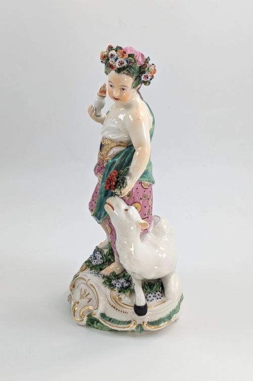 fig 1. An 18th-century Derby porcelain allegorical figure depicting Asia wearing a floral crown and patterned pink drapery alongside a camel on a scrollwork base.
