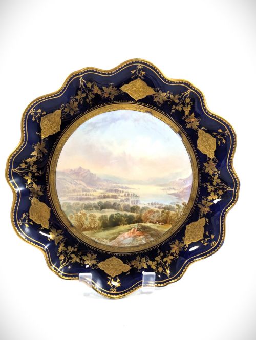 fig 1. A Victorian Aynsley porcelain cabinet plate featuring a central hand-painted landscape surrounded by a scalloped cobalt blue border with intricate gold leaf ornamentation.