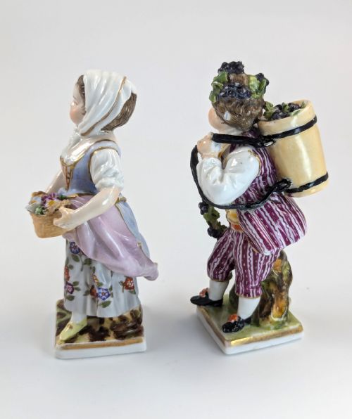 fig 1. Pair of late 19th-century Helena Wolfsohn porcelain child figurines featuring hand-painted floral attire, baskets, and gilded bases.