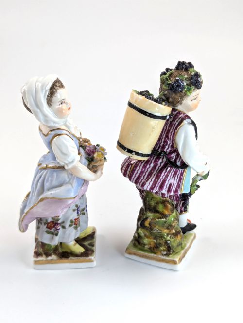 fig 3. Pair of late 19th-century Helena Wolfsohn porcelain child figurines featuring hand-painted floral attire, baskets, and gilded bases.