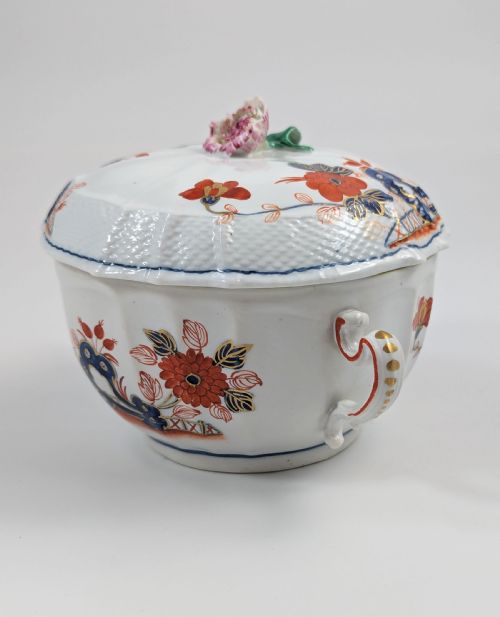 fig 1. An antique white porcelain lidded broth cup decorated with hand-painted red and blue floral motifs, featuring twin scroll handles and a sculpted floral lid finial.