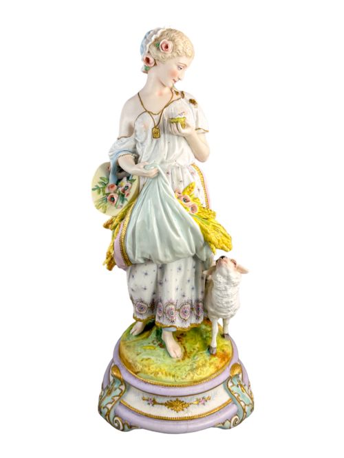fig 2. A pair of large French bisque porcelain sculptures featuring a shepherd and shepherdess with animals on gilded bases.