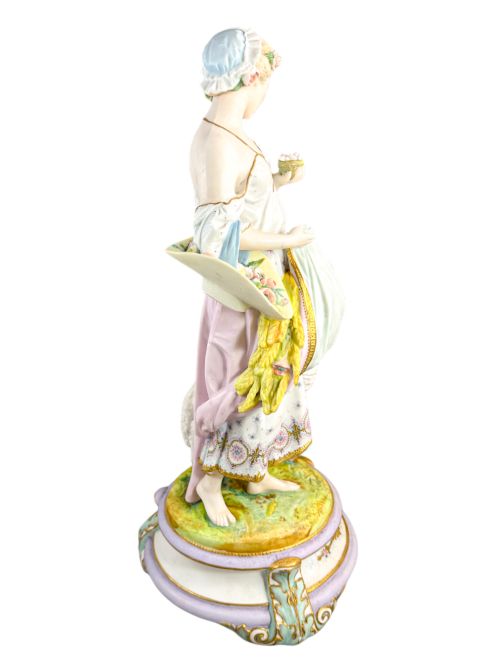 fig 3. A pair of large French bisque porcelain sculptures featuring a shepherd and shepherdess with animals on gilded bases.