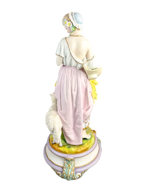 fig 4. A pair of large French bisque porcelain sculptures featuring a shepherd and shepherdess with animals on gilded bases.