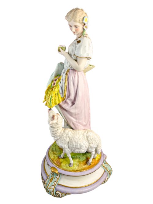 fig 5. A pair of large French bisque porcelain sculptures featuring a shepherd and shepherdess with animals on gilded bases.