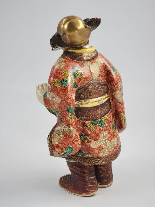 fig 2. A Japanese Kutani porcelain figurine depicting a bearded male figure in a red and gold patterned robe with raised moriage enamel detailing.