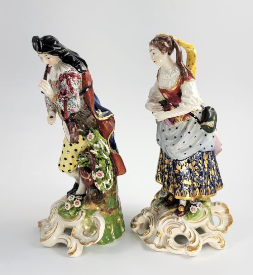 fig 1. A pair of 19th-century French Samson porcelain figures depicting a male musician with a pipe and drum alongside a female musician holding a triangle, set on gilded rococo scrollwork bases.