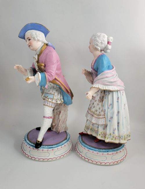 fig 1. A pair of late 19th-century French biscuit porcelain figures depicting an 18th-century courtly man and woman with pastel pink and blue painted garments.