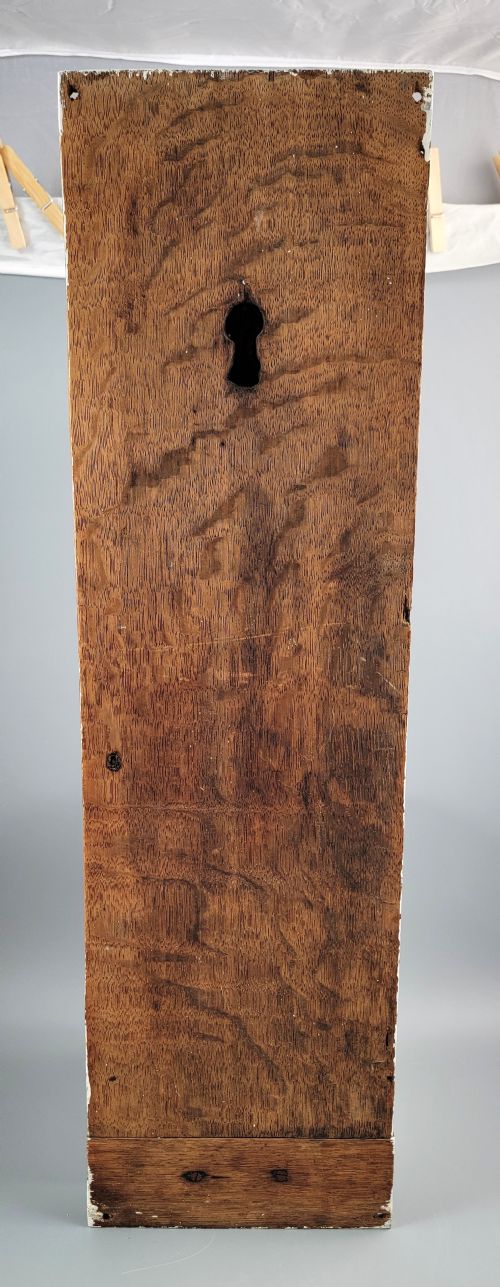 fig 2. A vertical carved oak panel displaying a high-relief figure of Faith holding a cross and a book beneath ornate Baroque scrollwork.