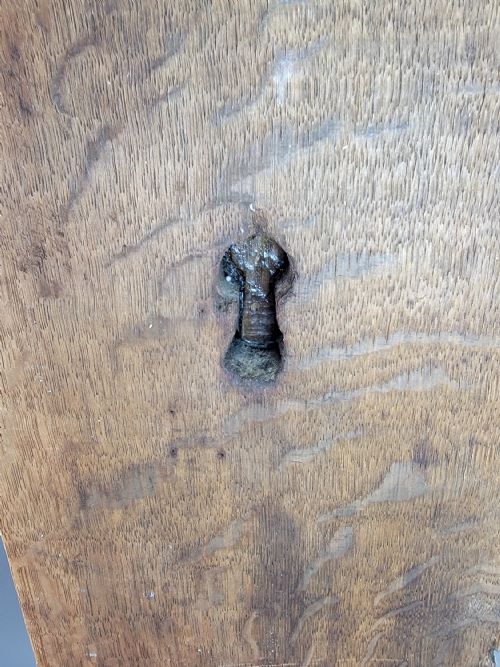 fig 5. A vertical carved oak panel displaying a high-relief figure of Faith holding a cross and a book beneath ornate Baroque scrollwork.