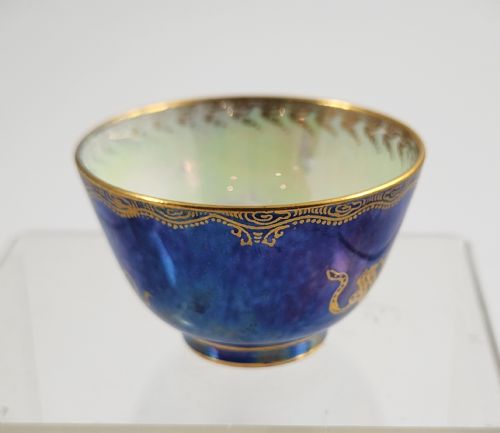 fig 1. A miniature Wedgwood lustre porcelain cup featuring a cobalt blue iridescent exterior decorated with gilded dragon motifs and a pale iridescent green interior.