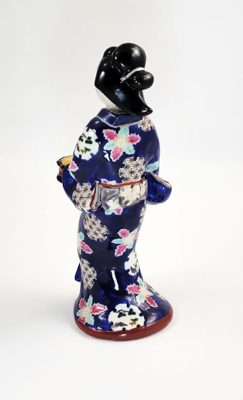 fig 2. Japanese Kutani porcelain figurine of a standing lady in a cobalt blue floral kimono playing a hand drum.