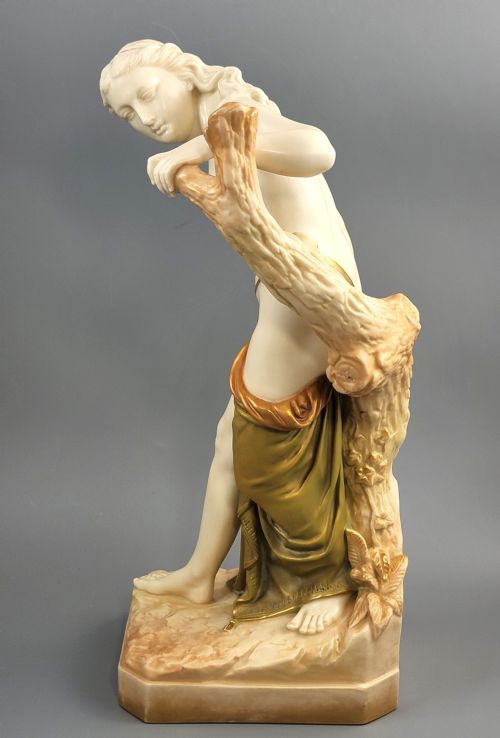 fig 1. An Edwardian Royal Worcester porcelain figure depicting a classical female bather leaning against a tree trunk, rendered in cream porcelain with gold shot enamel drapery.