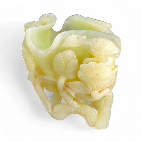 fig 1. A pale celadon green jade cup sculpted into the form of a lotus leaf with surrounding stems and buds.