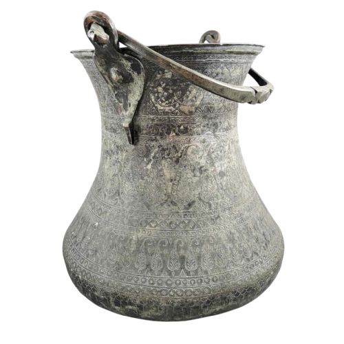 fig 1. An 18th-century Persian engraved bronze ritual vessel featuring repeating boteh patterns, a flared upper rim, and a curved metal swing handle.