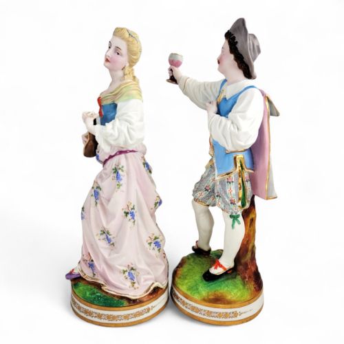 fig 1. A pair of nineteenth-century French porcelain figurines depicting a man raising a glass and a woman playing a lute, dressed in pastel polychrome attire on gilded bases.