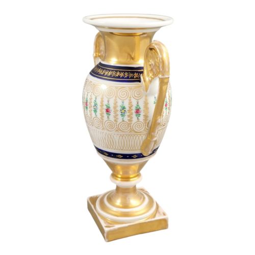 fig 1. An antique French Empire style white porcelain urn featuring gilded scroll handles, polychrome floral decoration, cobalt blue borders, and a gold pedestal base.