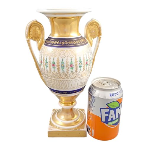 fig 2. An antique French Empire style white porcelain urn featuring gilded scroll handles, polychrome floral decoration, cobalt blue borders, and a gold pedestal base.