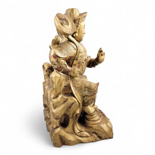 fig 2. A 19th-century carved wooden Chinese temple guardian figure with intricate gilded and polychrome surface detail seated on a carved rocky base.