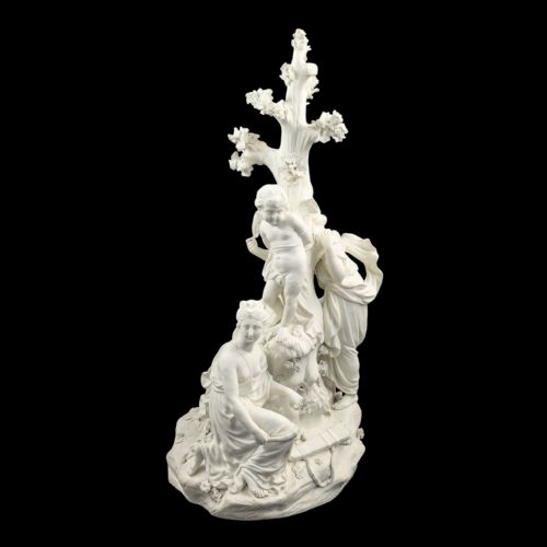 fig 1. An 18th-century white unglazed biscuit porcelain figure group depicting the Three Graces surrounding Cupid tied to a central tree trunk.
