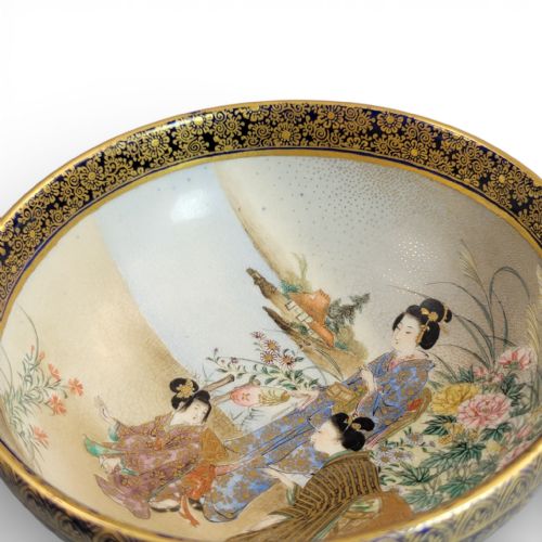 fig 1. A circular Japanese Satsuma earthenware bowl with hand-painted figures in a landscape and a dark cobalt blue and gilt border.