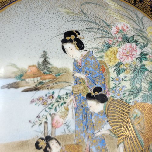 fig 2. A circular Japanese Satsuma earthenware bowl with hand-painted figures in a landscape and a dark cobalt blue and gilt border.