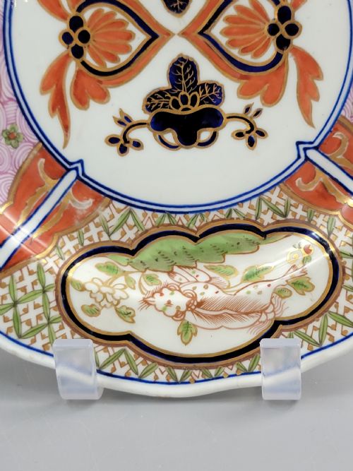fig 3. A pair of circular late 18th-century Derby porcelain plates featuring scalloped rims and hand-painted polychrome Kylin pattern designs in orange, cobalt blue, pink, and green.