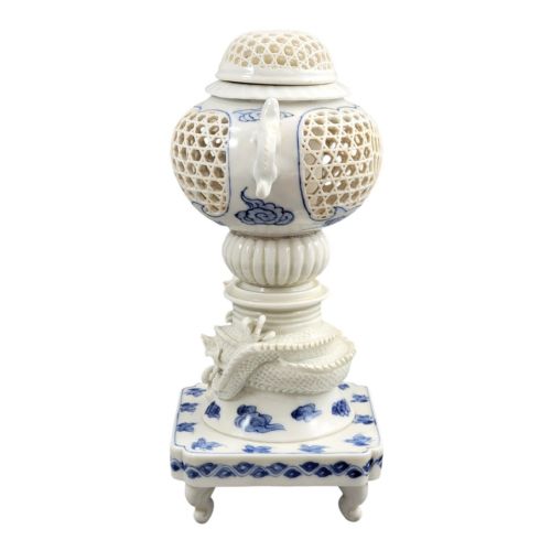 fig 2. A white and blue Japanese Hirado porcelain incense burner featuring a reticulated upper chamber, a sculpted dragon stem, and a square base.