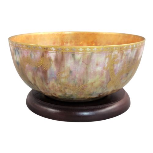 fig 4. A circular ceramic bowl featuring a mottled pink and purple iridescent lustre glaze adorned with detailed gilded dragon motifs.