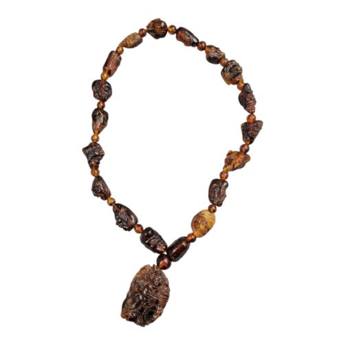 fig 4. A Chinese amber necklace featuring eighteen hand-carved luohan head beads and a figural carved pendant drop.