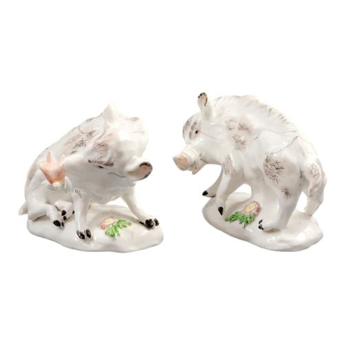 fig 1. A pair of 18th-century off-white porcelain figures depicting wild boars with painted bristle details set on low naturalistic bases with small floral motifs.