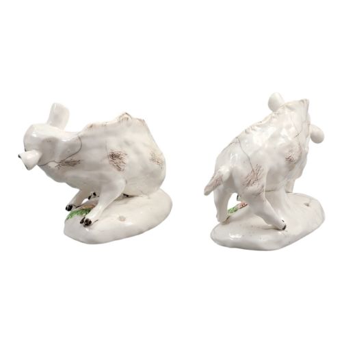 fig 2. A pair of 18th-century off-white porcelain figures depicting wild boars with painted bristle details set on low naturalistic bases with small floral motifs.