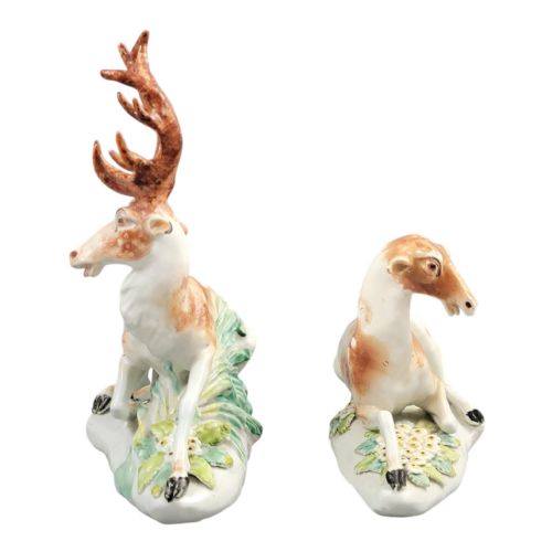 fig 3. A pair of 18th-century Derby porcelain figures depicting a reclining stag with branched antlers and a doe, painted with chestnut-spotted coats on floral-adorned white bases.