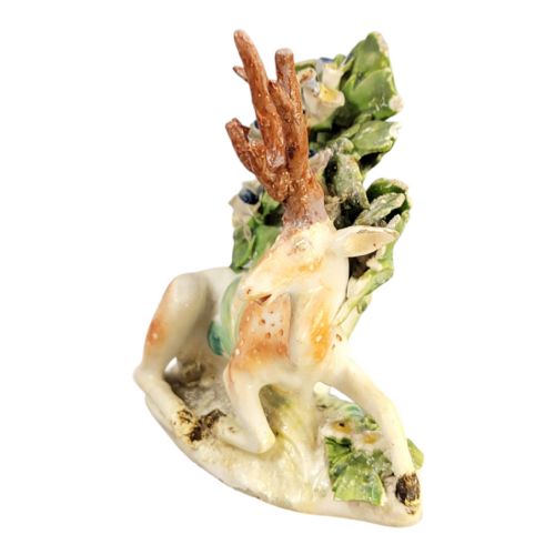 fig 1. An 18th-century Derby porcelain figure depicting a spotted recumbent stag sitting before a leafy floral bocage backdrop.