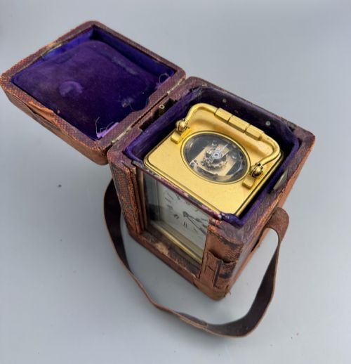 fig 2. A late 19th-century French brass carriage clock housed inside a protective, textured brown leather travelling case with a leather carrying strap.