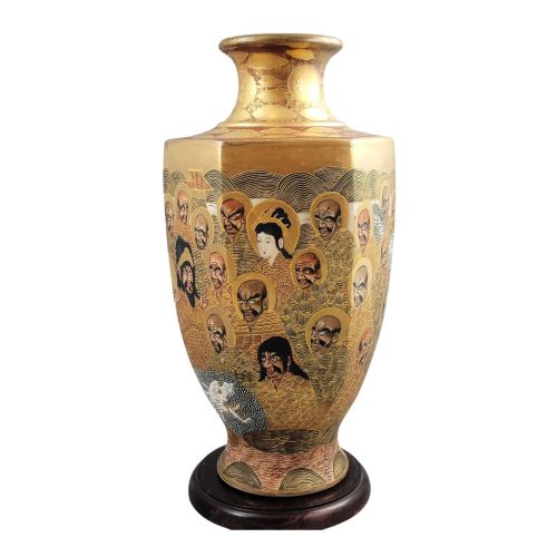 fig 1. A tall gilded Japanese Satsuma earthenware vase painted with figures of Arhats and a dragon, set on a dark wooden base.
