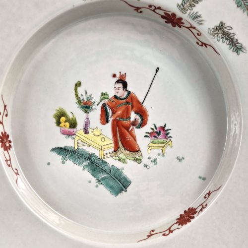 fig 1. A late Qing dynasty Chinese Famille Rose porcelain dish featuring a hand-painted central figure, lotus blossoms, butterflies, and a distinct red castellated rim.