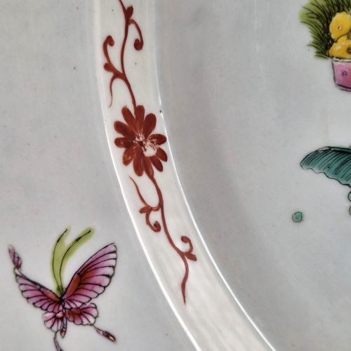 fig 3. A late Qing dynasty Chinese Famille Rose porcelain dish featuring a hand-painted central figure, lotus blossoms, butterflies, and a distinct red castellated rim.