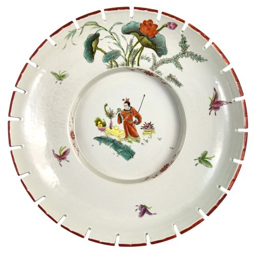 fig 5. A late Qing dynasty Chinese Famille Rose porcelain dish featuring a hand-painted central figure, lotus blossoms, butterflies, and a distinct red castellated rim.