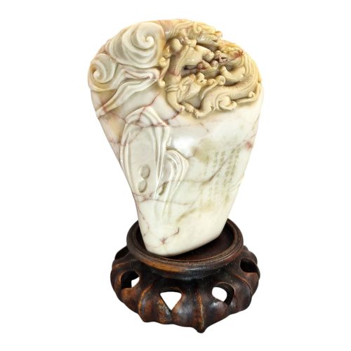 fig 6. A carved cream and tan Shoushan stone sculpture depicting a dragon amongst clouds set upon a dark turned wooden base.