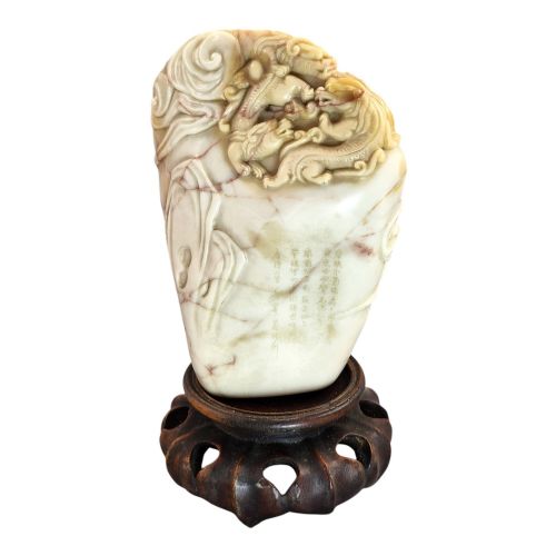 fig 7. A carved cream and tan Shoushan stone sculpture depicting a dragon amongst clouds set upon a dark turned wooden base.
