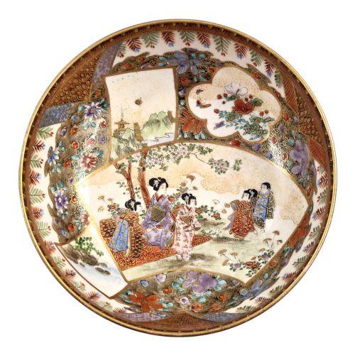 fig 1. An antique Meiji period Japanese Satsuma earthenware bowl featuring hand-painted floral panels and gold detailing, elevated on a carved dark wooden base.